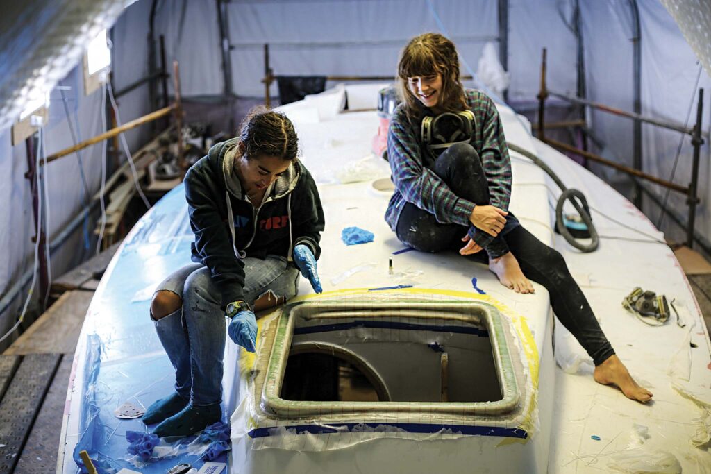 Chloë Peglau and Lily Journeaux fit the forward hatch during Elixir’s refit. Photo Courtesy of Max Campbell