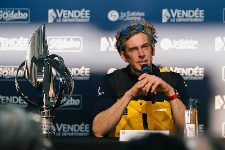 Dalin sitting at a table surrounded by microphones