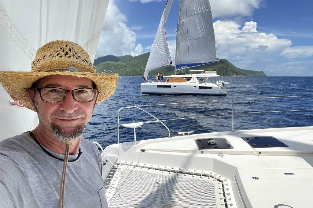 A man in a boat on the water with boats behind them
