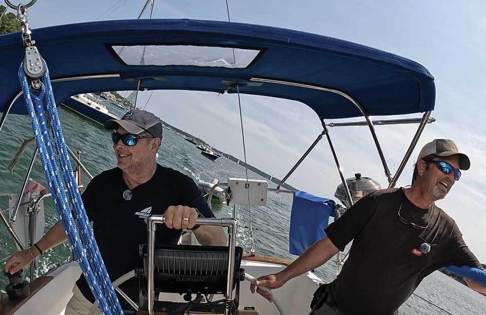 two men on a boat under a blue doger
