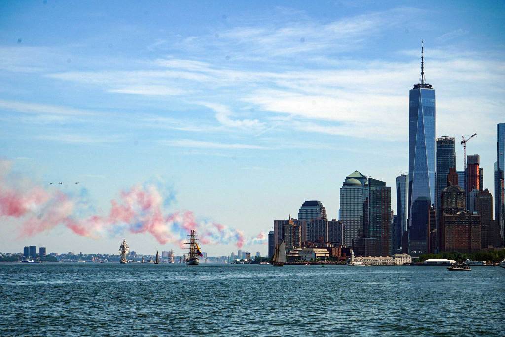 Tallship in NYC harbor blowing patriotic red and blue smoke