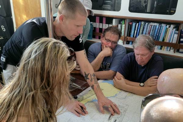 The author demos navigation skills on paper charts.